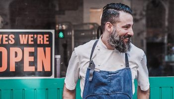 Ein Unternehmer steht vor deinem Laden und macht sich über Marketing Strategien Gedanken.